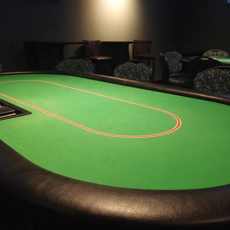 Empty poker table with green felt after closing